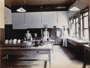 view Johannesburg Hospital, South Africa: kitchen area with staff, tea pots and cake. Photograph, c. 1905.