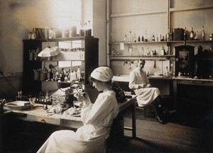 view Military Hospital V.R. 76, Ris-Orangis, France: nurse examining a small object with a magnifying glass. Photograph, 1916.