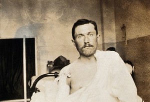 view Military Hospital V.R. 76, Ris-Orangis, France: male patient, infantry soldier from front line, with dressed wound on right shoulder. Photograph, 1916.