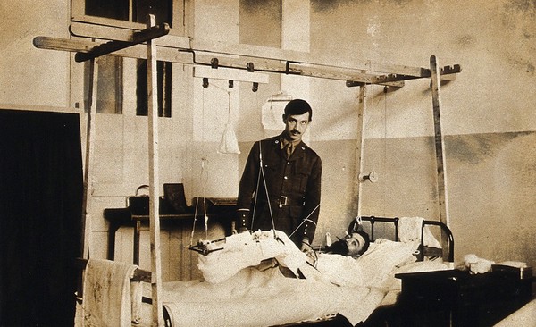 Military Hospital V.R. 76, Ris-Orangis, France: man with leg in traction, wounded at Verdun in World War I. Photograph, 1916.