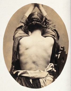 view A woman, viewed from behind with open dress revealing back; she is holding her arms up. Photograph by L. Haase after H.W. Berend, 1863.