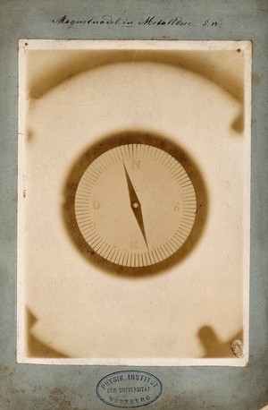 view A compass whose magnetic needle is entirely surrounded by metal, viewed through x-ray. Photoprint from radiograph by W.K. Röntgen, 1895.