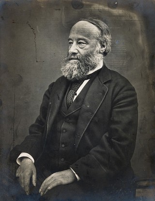 James Prescott Joule (1818-1889), seated, facing right. Photograph by L. Roscoe, c. 1890.