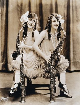 Daisy and Violet Hilton, conjoined twins, with saxophones. Photograph, c. 1927.