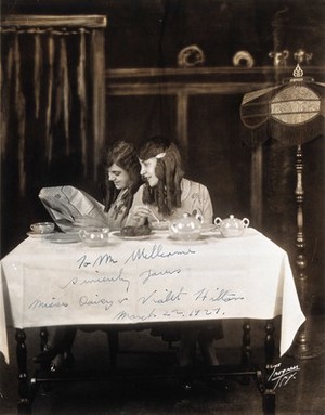 view Daisy and Violet Hilton, conjoined twins, taking tea. Photograph, 1927.