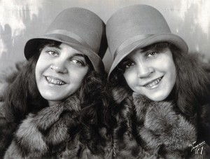 view Daisy and Violet Hilton, conjoined twins, head and shoulders, wearing fur coats. Photograph, c. 1927.