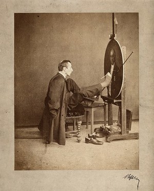 view A man painting an oval portrait using his feet. Photograph by J. Dupont, c. 1870.