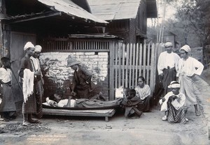 view An outdoor examination of a plague patient in Mandalay. Photograph, 1906.