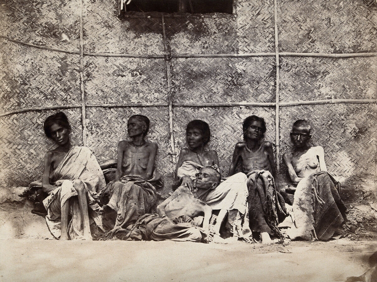 Famine in Mysore, India: six emaciated women, five sitting and one leaning on another's lap. Photograph attributed to Willoughby Wallace Hooper, 1876/1878., 1876, by Willoughby Wallace Hooper