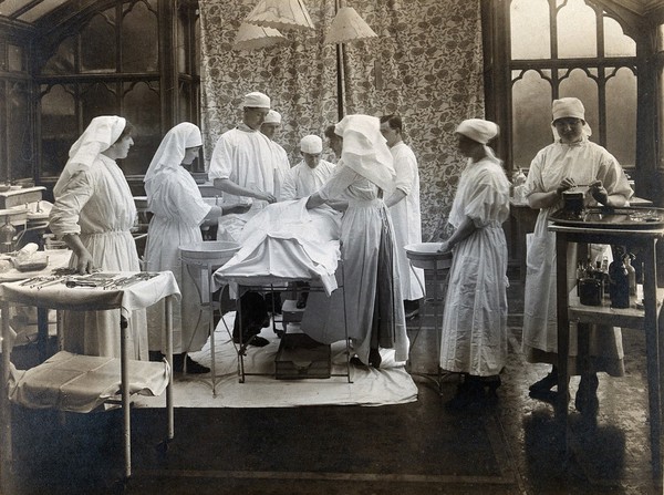 Mount Stuart Royal Naval Hospital, Isle of Bute: surgical staff performing an operation. Photograph, 191-.