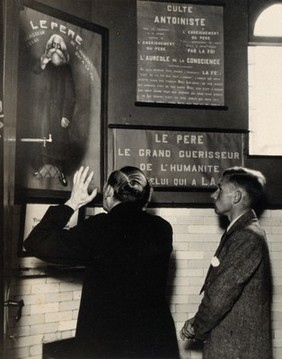 Temple of the Antoinistes, Liège: the priest faces a portrait of Father Antoine, entreating him to help heal a sick follower. Photograph by Kurt Lubinski, 1920/1940.