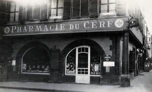 view The front door of the Pharmacie du Cerf on the corner of the street, Strasbourg. Photograph.