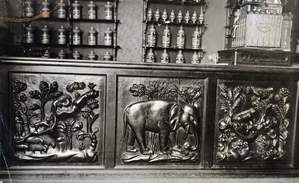 A seventeenth-century wooden pharmacy counter carved in low relief, the central panel is of an elephant. Photograph.