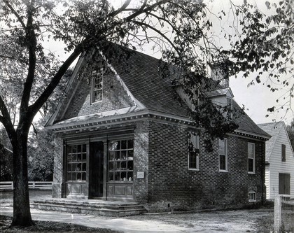 The exterior of a small brick building used as an apothecary shop by Dr. Archibald Blair in the eighteenth century, Virginia. Photograph.