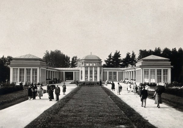 Franzensbad (Františkovy Lázně), Czechoslovakia: an exterior view of the two paths leading to the inner part of a c-shaped building which houses the Natalie Spring. Photograph.