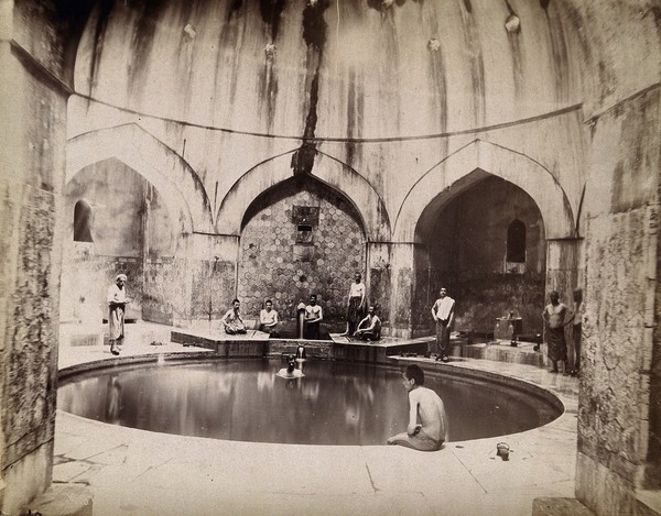 Bursa, Turkey: bath of Suleiman the Magnificent (Yeni Kaplıca), with men sitting around the sides of a circular pool in the domed building. Photograph.
