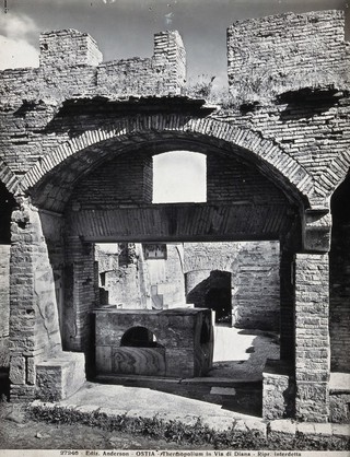 Partly ruined buildings in Ostia identified as a tavern or hot-food shop (thermopolium) from the 3rd century AD. Photograph by Anderson, 192-.
