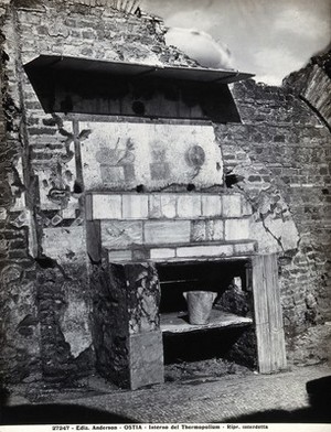 view Partly ruined buildings in Ostia identified as a tavern or hot-food shop (thermopolium) from the 3rd century AD: marble steps below a fresco illustrating vegetables, wine and fruit. Photograph by Anderson.