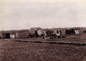 view A camp of huts made out of bamboo and matting, where refugees from Bombay live and work during the plague. Photograph, 1896/1897.