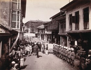 view A group of officials making a visit to a house in Bombay, suspected of holding people with plague. Photograph, 1896.
