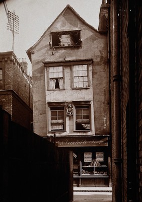 The church of St. Bartholomew the Great and surrounding area; Warwick House, the bottom of which is a fruit and vegetable shop. Photograph by W.F. Taylor.