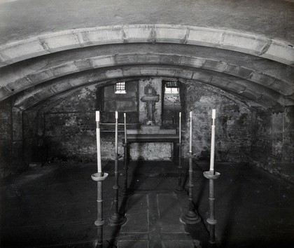 The church of St. Bartholomew the Great; interior of the crypt with two lines of long candlesticks in their holders. Photograph by W.F. Taylor.