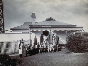 view Metropolitan Lunatic Asylum, Kew, Victoria (Australia): the hospital cook and the boys who help him, on the steps of the kitchen cottage. Photograph.