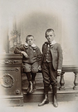 view Two boys, one sitting and one standing: the former appears physically deformed. Photograph, 1899.