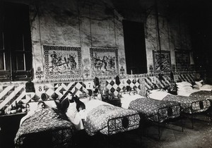 view Hospital de la Santa Cruz, Barcelona: a ward for male patients, with tiles on the wall depicting the stations of the cross. Photograph.