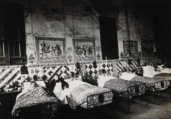 Hospital de la Santa Cruz, Barcelona: a ward for male patients, with tiles on the wall depicting the stations of the cross. Photograph.