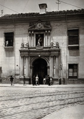 Hospital San Juan de Diós, Granada: gateway of the hospital showing the stone figure of the founder above. Photograph, ca.1900.