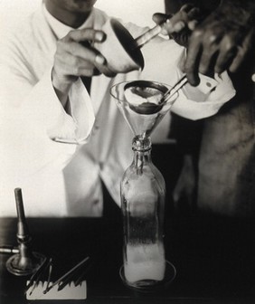 The Pasteur Institute, Kasauli, India: stages in the preparation of the rabies vaccine: straining an emulsion, made using infected rabbit brain, into a bottle. Photograph, ca. 1910.