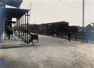 view Colón, Panama: newly paved street junction with pedestrians, carriages and train carriages. Photograph, 1906.