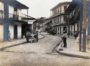 view North Avenue, Panama: newly paved busy street with carriages, residents and workers; lined with large buildings with balconies. Photograph, 1907.