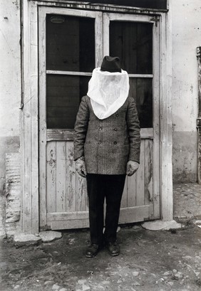 The anti-malaria school, Nettuno, Italy: a man wearing face-protection and gloves to protect against mosquitos. Photograph, 1918/1937 (?).