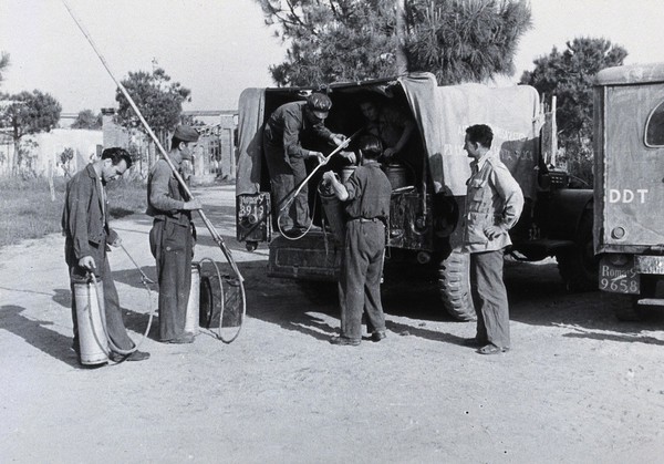 Malaria control equipment being unloaded from a truck by men, Italy. Photograph, 1940/1950 (?).