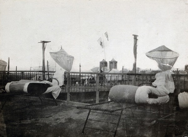 Israel (?): mosquito nets and folded mattresses on camp beds: the rooftop of a military hospital. Photograph, 1914/1940 (?).