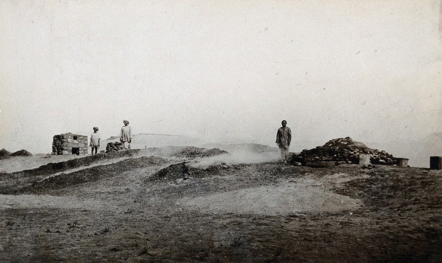 India: the Bikanir Camel Corps conservancy area ferry post: incinerators in the desert with Indian men. Photograph by J.D. Graham, 1900/1910.