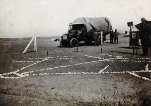 The sanitary demonstration area, with an army truck and soldiers, on a First World War (?) army camp, Abassia, Cairo, Egypt: marked out on the ground is a model of the reticulation system of trenches for waste disposal. Photograph, 1914/1918 (?).