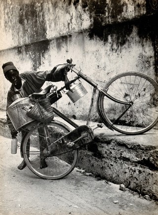A bicycle with milk pails, held by an African boy, Zanzibar, Tanzania. Photograph by Dr. Andrew Balfour, ca. 1910 (?).