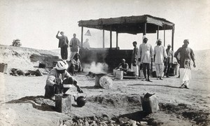 view A cook-house surrounded by men in turbans, at a (military ?) ferry post, in the Suez Canal area (?). Photograph by J. D. Graham, 1914/1918.