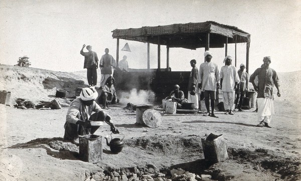 A cook-house surrounded by men in turbans, at a (military ?) ferry post, in the Suez Canal area (?). Photograph by J. D. Graham, 1914/1918.