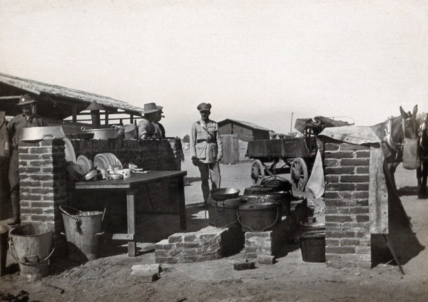 Abassia, Cairo, Egypt: the outside cooking area of a military camp, with soldiers and horse-drawn carts. Photograph, 1914/1918 (?).