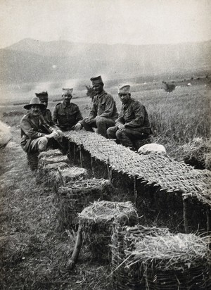 view Serbian soldiers (during the first world war ?) in a field with improvised seats and a table made from wicker. Photograph, 1914/1918 (?).