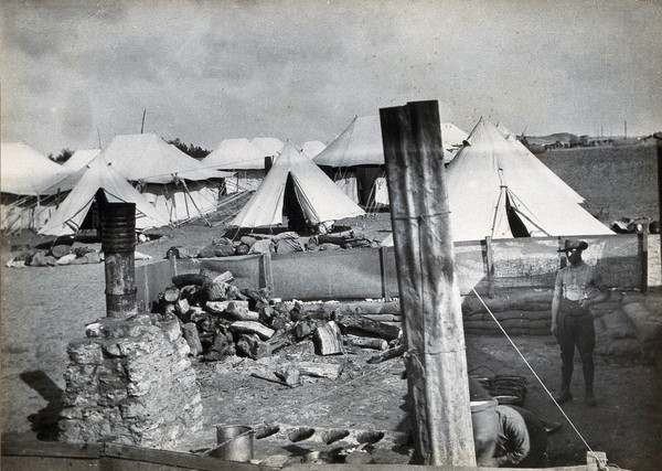 Serapeum, Egypt (Suez Canal area): the Australian military camp Casualty Clearing Station cooking area with a soldier in the foreground and tents in the background. Photograph, 1914/1918 (?).