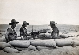 view Sinai Desert, Egypt: first world war (?) front line trenches; a machine gun with three (British ?) soldiers. Photograph, 1914/1918 (?).