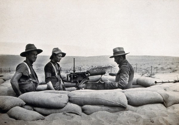 Sinai Desert, Egypt: first world war (?) front line trenches; a machine gun with three (British ?) soldiers. Photograph, 1914/1918 (?).