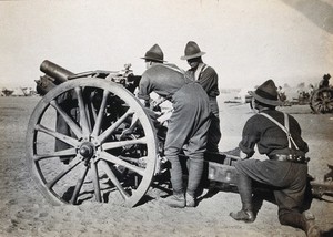 view Moascar, Egypt: a New Zealand howitzer gun on a first world war camp with three soldiers. Photograph, 1914/1918 (?).