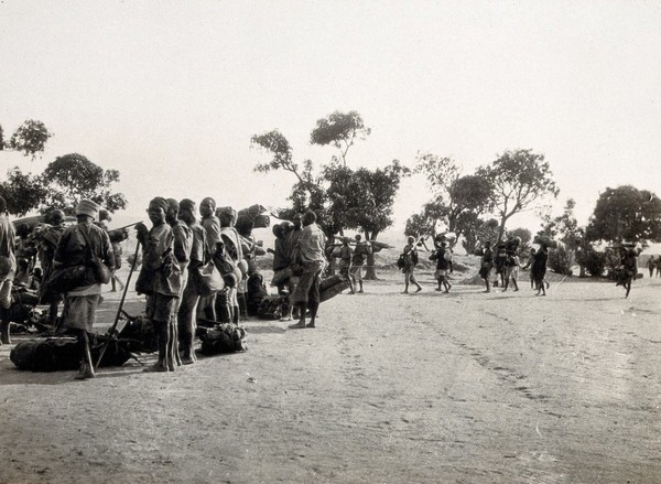 Tabora, Tanzania: Tanzanian men carrying or standing next to bags. Photograph, 1914/1918.