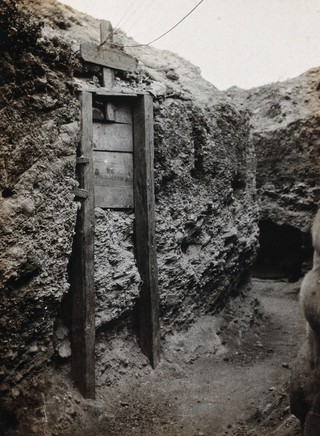 Gallipoli, Turkey: Australian and New Zealand Army Corps (ANZAC) grave with a makeshift wooden cross, in an ANZAC trench. Photograph, 1915.